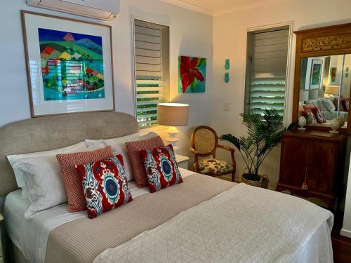 um quarto com uma cama com almofadas em Casa Palma em Mission Beach