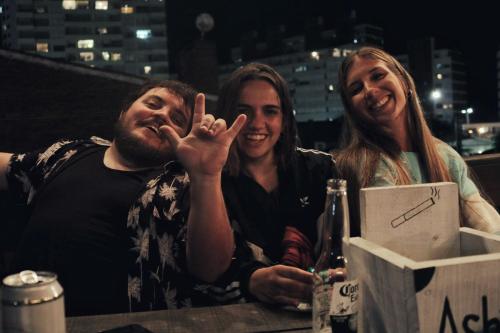 two women and a man making the peace sign with their hand at The Trip Hostel in Punta del Este