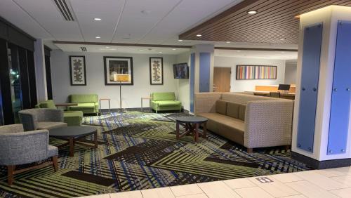 a lobby with chairs and a couch and tables at Holiday Inn Express & Suites - Middletown by IHG in Middletown