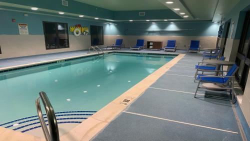 a large swimming pool with blue chairs and a table at Holiday Inn Express & Suites - Middletown by IHG in Middletown