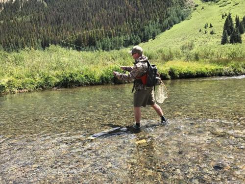 a man is standing in a river with a fish at Holiday Inn Express Durango Downtown- Animas River in Durango