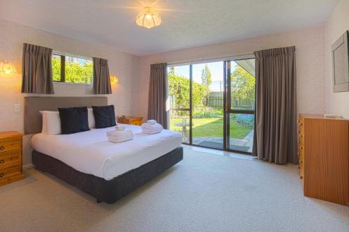 a bedroom with a bed and a large window at Sunny Warren in Wanaka in Wanaka
