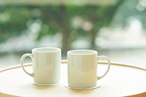 two white coffee mugs sitting on a table at Sotetsu Fresa Inn Daimon in Tokyo