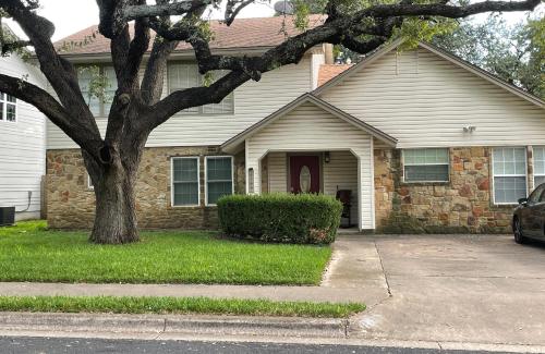 una casa de ladrillo con un árbol delante de ella en CASA ATX- Private room and Bathroom in Quiet Neighborhood, en Austin