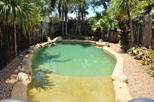ein kleiner Pool in einem Garten mit einem Zaun in der Unterkunft Cooktown Motel in Cooktown
