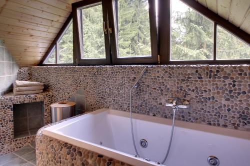 a large bath tub in a bathroom with windows at Medvědí skála in Čeladná