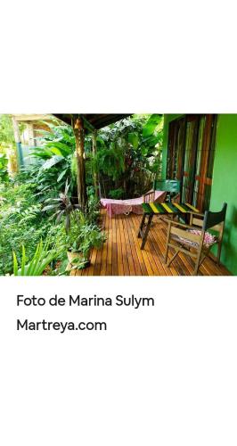 a porch with a hammock on a wooden deck at Jardín de Naipí in Puerto Iguazú