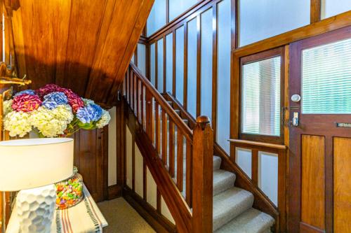 a room with a staircase with a vase of flowers at The Magnolia Villa CBD in Timaru