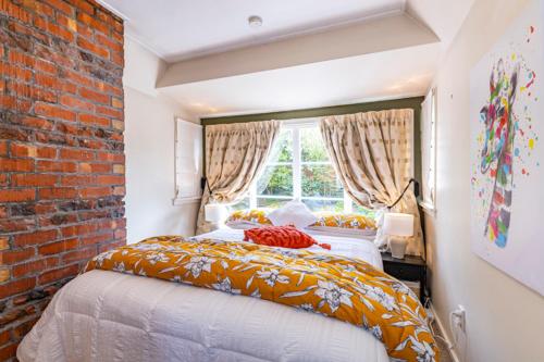 a bedroom with two beds and a brick wall at The Magnolia Villa CBD in Timaru
