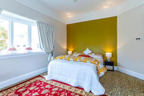 a bedroom with a bed and a window at The Magnolia Villa CBD in Timaru