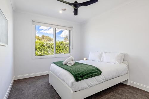 Un dormitorio blanco con una cama y una ventana. en Rio Vista - Luxury Accommodation, en Rye