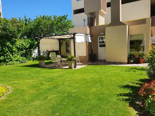 a yard with a gazebo and a green lawn at Casa Golfo Nuevo in Puerto Madryn