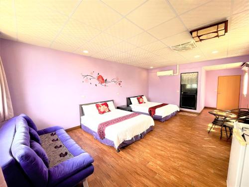 een hotelkamer met 2 bedden en een bank bij 台東新港民宿 in Chenggong
