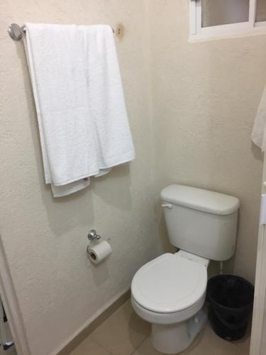 ein Bad mit einem weißen WC und einem Handtuch in der Unterkunft Acapulco, Departamento PB en Marina Diamante in Acapulco