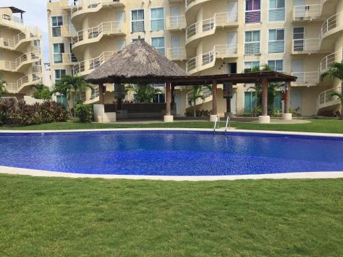 a swimming pool in front of a large apartment building at Acapulco, Departamento PB en Marina Diamante in Acapulco