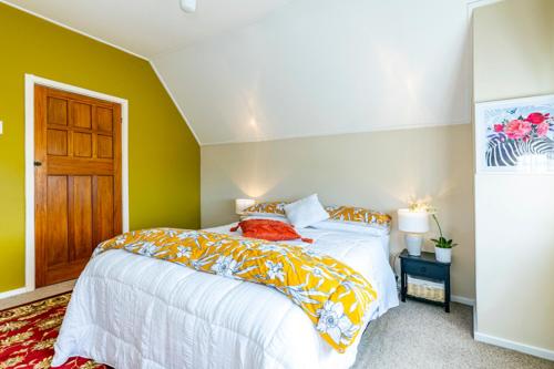 a bedroom with a large bed with yellow walls at The Magnolia Villa CBD in Timaru