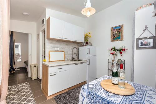 a small kitchen with a table and a refrigerator at House Green Oasis in Vodice