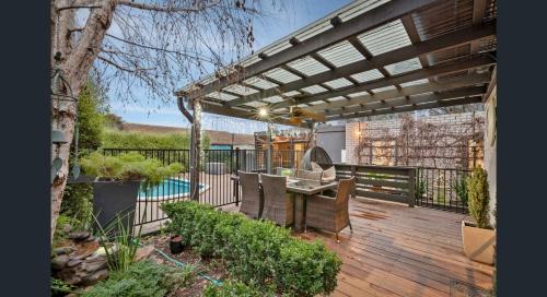 a wooden deck with a pergola and a table and chairs at The Weeping Elm - Large and Spacious in Albury