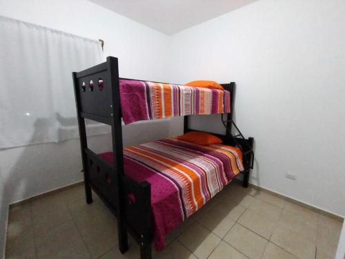 a black bunk bed with a colorful blanket on it at Departamento 3 habitaciones in Cancún