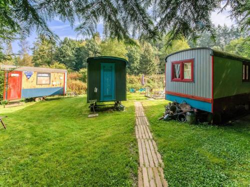 three tiny homes sitting on the grass under a tree at Holiday Home in Houffalize With Terrace in Houffalize