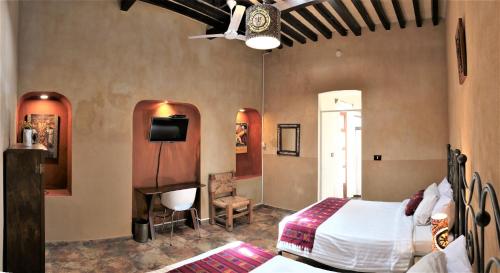 een slaapkamer met een bed en een tv. bij Hotel Boutique Casona Cantera Querétaro in Querétaro