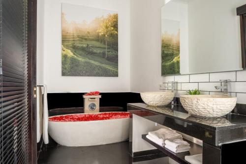 a bathroom with a tub and two sinks at Jagaditha Villas in Sanur