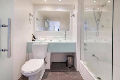 a bathroom with a toilet and a sink and a shower at Nightelier Devonport Gateway Hotel in Devonport