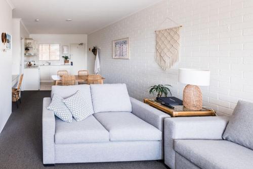 a living room with a couch and a table at Mollymook Seascape Motel and Apartments in Mollymook
