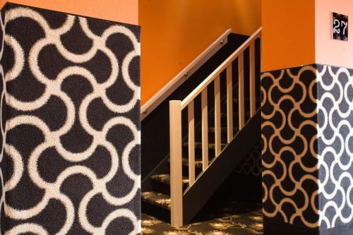 a room with a staircase with orange walls at Hotel Roermond Next Door in Roermond