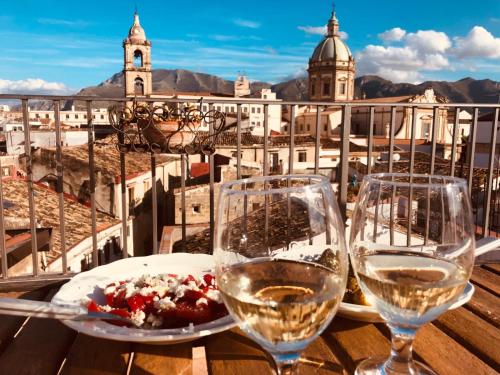 パレルモにあるCasa Viglienaの市街の景色を望むテーブルの上にワイン2杯