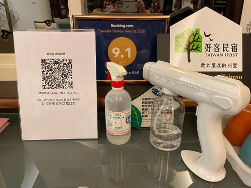 a bottle of cleaner sitting on a table next to a machine at Mandy's House B&B in Shangwu