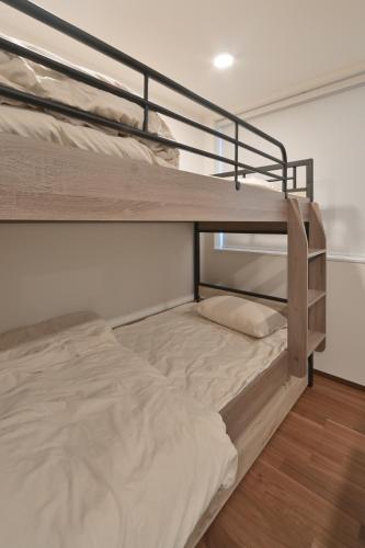 a couple of bunk beds in a room at Stylewood Nishi-Shinjuku by Tranova in Tokyo