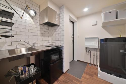 a small kitchen with a sink and a counter at Stylewood Nishi-Shinjuku by Tranova in Tokyo