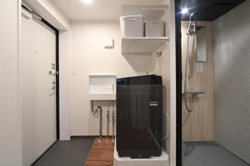 a small bathroom with a shower and a toilet at Stylewood Nishi-Shinjuku by Tranova in Tokyo