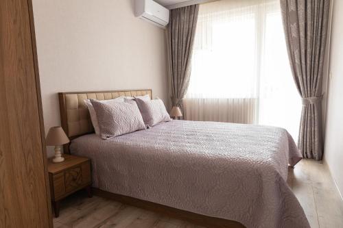 Schlafzimmer mit einem großen Bett und einem Fenster in der Unterkunft Central Point Premium + in Ruse