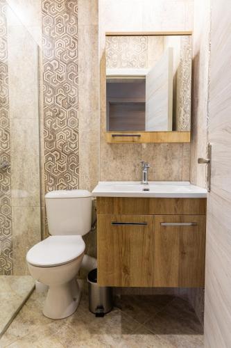 a bathroom with a toilet and a sink at Central Point Premium + in Ruse