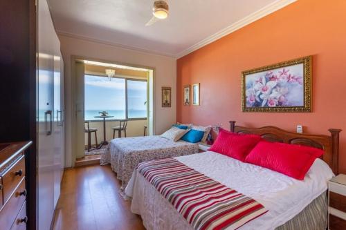 2 camas en un dormitorio con paredes de color naranja en 2440 Avenida Atlântica, Copacabana Vista Total Mar, en Río de Janeiro