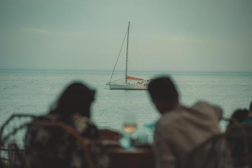 a group of people looking at a sail boat in the ocean at Puerto Azul Marbella in Marbella