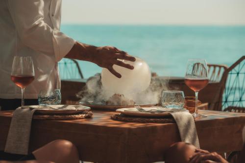 a man standing over a table with glasses of wine at Puerto Azul Marbella in Marbella