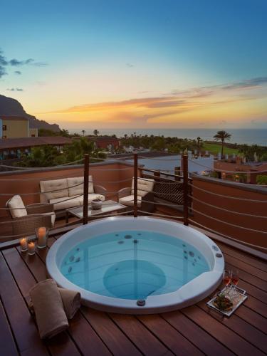 a hot tub on a deck with the sunset at Hotel Hacienda del Conde Meliá Collection Golf & Spa - Adults Only in Buenavista del Norte