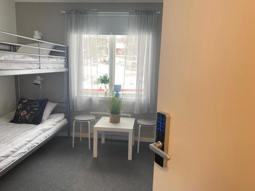 a small room with a bed and a table and a window at Åsbergbo Vandrarhem in Vallsta