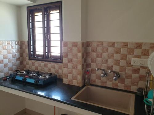 una cocina con estufa y fregadero en Chippy Apartments 3006B, en Chennai