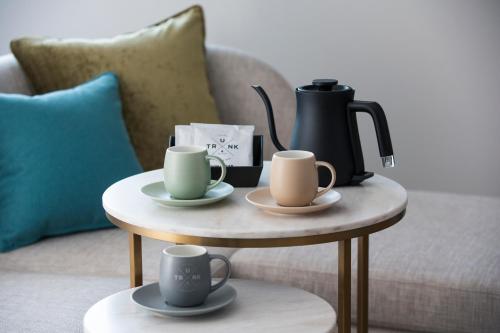 a coffee table with two cups and a coffee maker on it at Nikko Style Nagoya in Nagoya