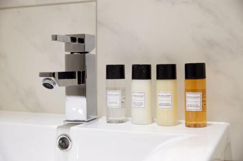 a group of four bottles of cosmetics sitting on a counter at 5VH Virginia House, 31 Bloomsbury Way in London