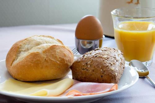 a plate with two loaves of bread and an egg on a table at Antonius Hoeve in Oudenbosch
