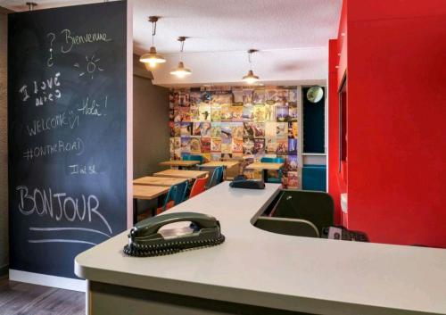 a restaurant with a desk with a phone on the counter at Eco hôtel Rouen Louviers Val de Reuil in Val de Reuil