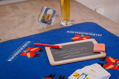 a table with a chalkboard and a pen and a drink at Alpenresort Eienwäldli Engelberg in Engelberg