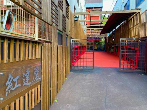 an empty hallway with red gates in a building at Benidaruma - Dango in Kyoto