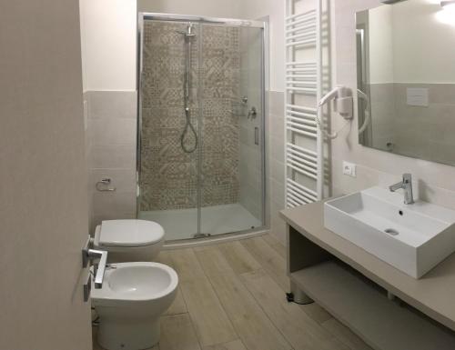 een badkamer met een douche, een toilet en een wastafel bij TERRAZZA Rooms in Castrezatto