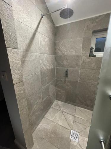a bathroom with a shower with a glass door at Beautiful self-catering cottages, Ribble Valley in West Bradford